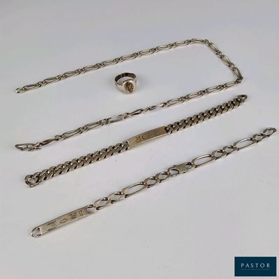 trois morceaux de chaîne en argent avec un fermoir, posés sur une surface blanche