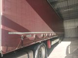 a red semi truck parked inside of a building