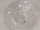 a clear glass object on a table with a white background
