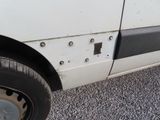 a close up of a white van with holes in the side