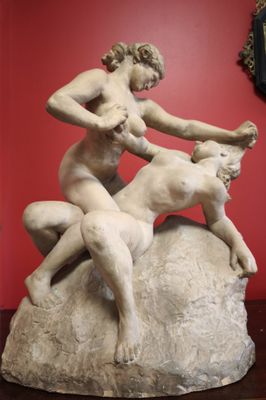 a statue of a woman on a rock with a goat