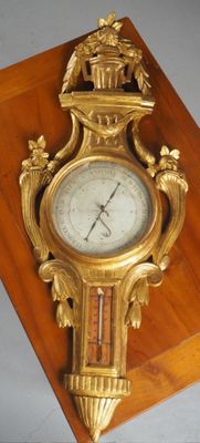 une horloge dorée posée sur un socle en bois accroché au mur
