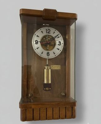 une horloge en bois avec une vitre, accrochée au mur