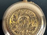 a close up of a gold pocket watch on a black surface