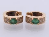 a pair of emerald and diamond earrings