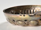 a silver bowl with a spoon in it on a table