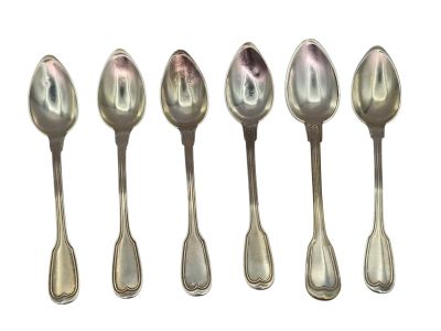 six silver spoons are lined up in a row on a white surface
