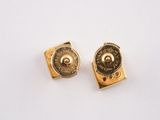 pair of gold tone cufflinks with a small button on each side