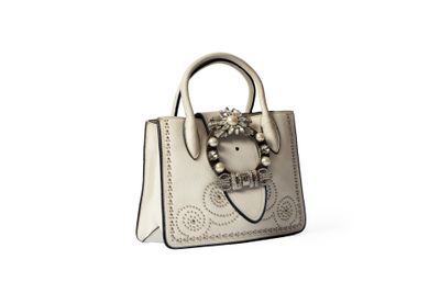 sac à main en cuir beige avec des ornements métalliques et des anses ornées de perles