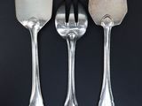 three spoons and a fork on a black table