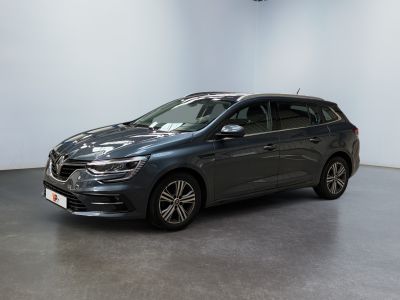 Une voiture grise est garée dans une pièce aux murs blancs.