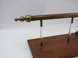 an antique brass plated telescope on a wooden stand on a white background