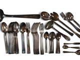beaucoup de cuillères, de fourchettes et de cuillères disposées sur la table