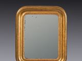 an antique gold framed mirror with a black background