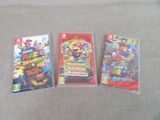 trois jeux Nintendo Wii posés sur un canapé