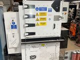 an image of a machine in a factory with cans of soda