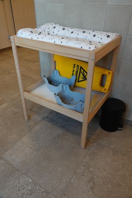une table à langer dans un coin de la salle de bains