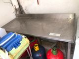 a stainless steel table with two blue containers underneath it