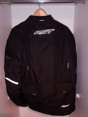 La veste est suspendue à un cintre dans un coin de la pièce.