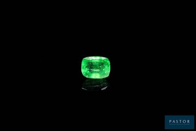 a green emerald stone on a black surface