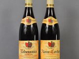 two bottles of wine sitting on top of a table next to each other
