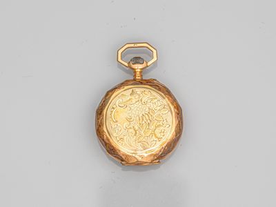 une vieille montre de poche en or, avec une chaîne suspendue sur le côté