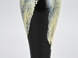 a black vase with a yellow and white design on it