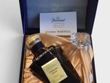 une photo d'un flacon de parfum posé dans une boîte