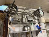 de nombreuses casseroles et poêles suspendues au plafond de la cuisine