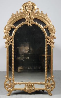une image représentant un miroir à cadre doré orné d'une tête de lion