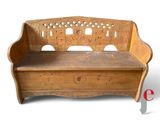 un banc en bois dont le dossier est orné de sculptures