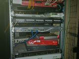 a rack with many wires and a laptop on it