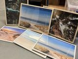 une pile de photos posée par terre à côté d'une pile de livres