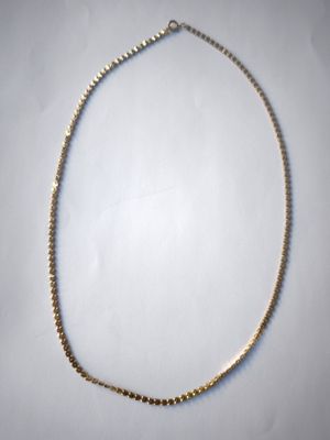 a close up of a necklace on a white surface