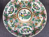 three plates with flowers and birds on them on a table