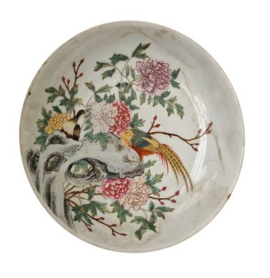 une assiette blanche décorée d'un oiseau et de fleurs