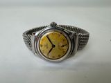 an image of a silver watch with a yellow face on a white surface
