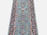 un tapis bleu à motifs floraux et à franges