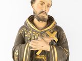 figurine of a saint holding a cross in his hands