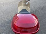 un scooter rouge et blanc garé sur le bord de la route