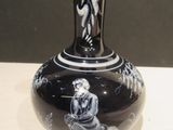 a black and white vase with a picture of a woman on it