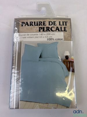 emballage d'un lit avec une couette bleue et un oreiller