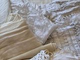 a lot of laces on a bed with a white comforter