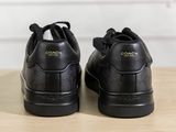 black leather sneakers with coach logo on the soles