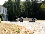 a silver car parked in front of a white house