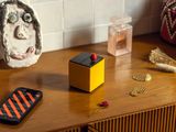 a cell phone sitting on a wooden table next to a vase