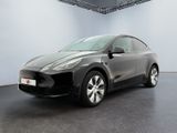 La Tesla Model Y noire est garée dans une pièce blanche