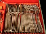 many forks and spoons in a case on the table
