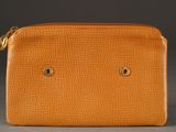 un sac à main en cuir orange avec deux petits trous sur le devant