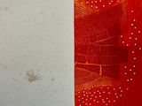 une œuvre d'art rouge accrochée à un mur blanc